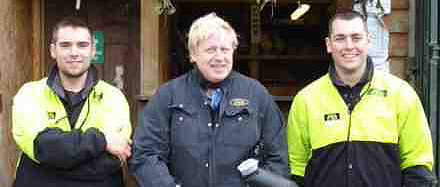 Boris Johnson smiles with two marshals