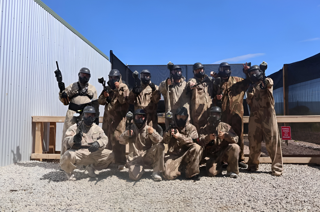 Paintball group in fancy dress posing by a scoreboard