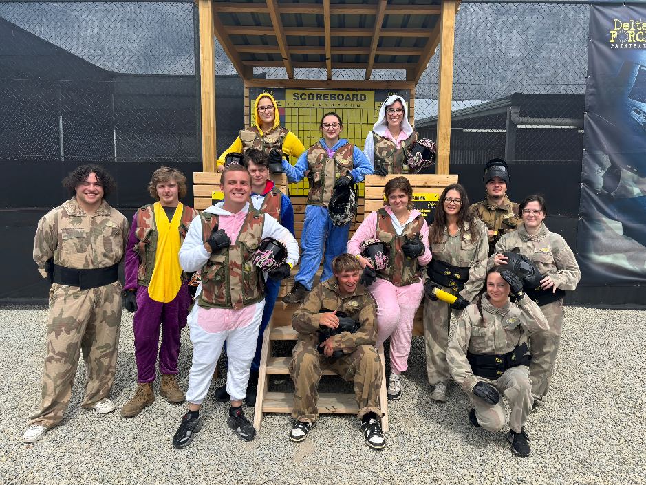 Paintball players taking cover in a wooden game zone