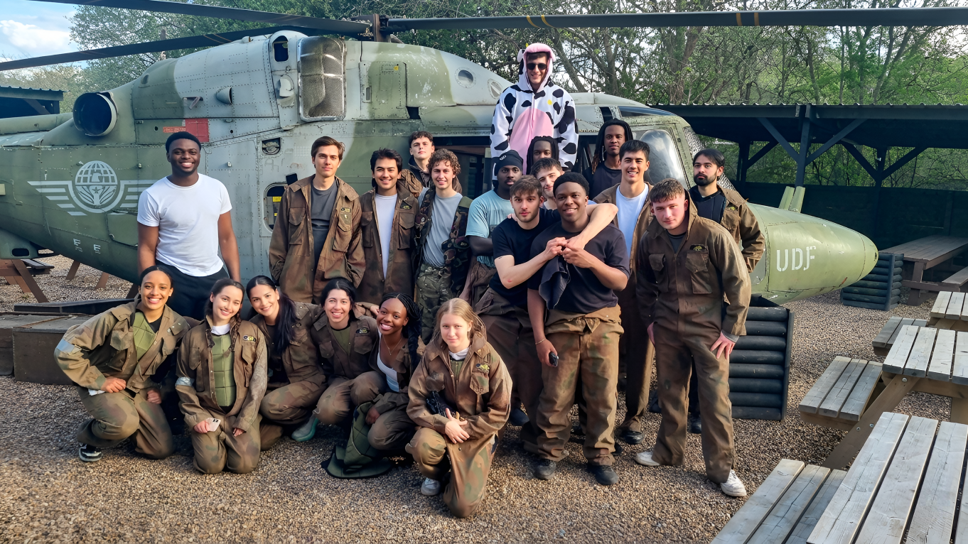 Paintball team posing with markers after a game