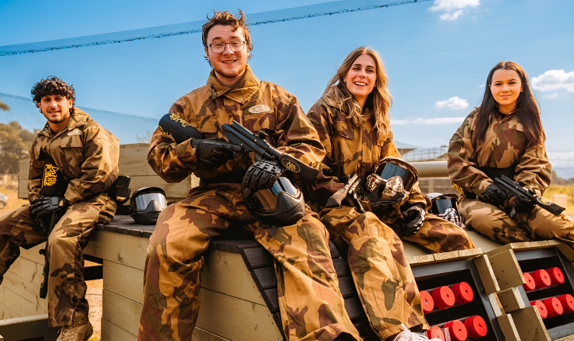 Group of adult paintball players posing together outdoors
