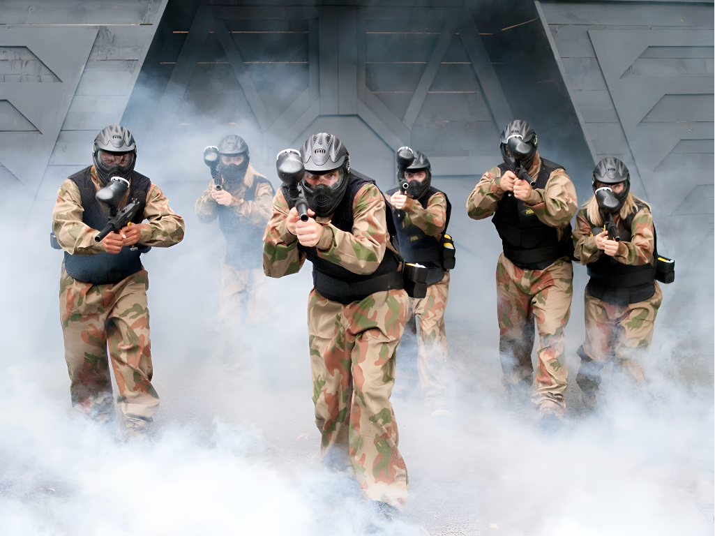 Paintball team advancing through smoke in camouflage kit