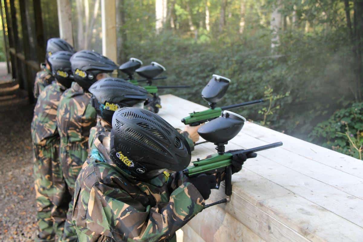 School paintball players aiming from cover