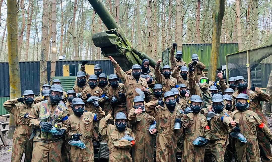 Large school paintball group posing after a game