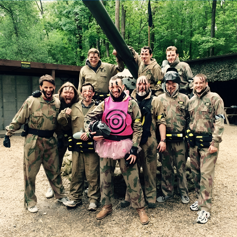 Stag paintball group smiling in camouflage kit with the stag in fancy dress