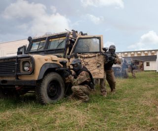 Delta Force Players Crowded Round Military Vehicle