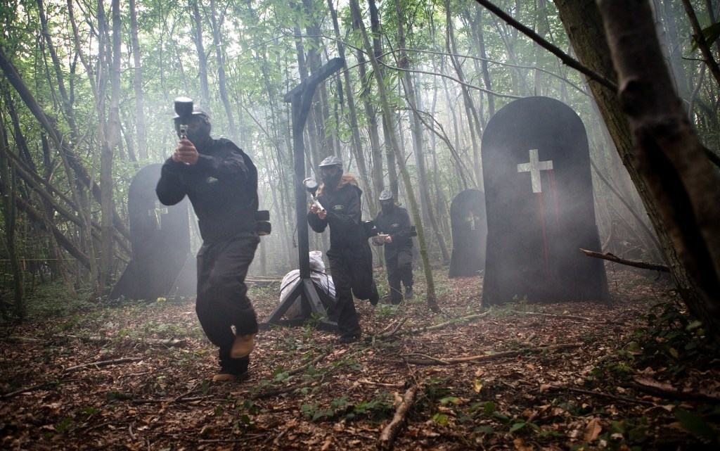 Paintball Players Run In Woods With Smoke And Grave Prop