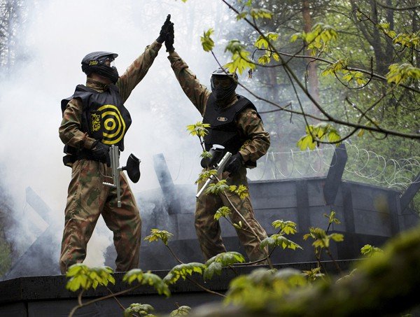 Two players high five, one wearing yellow target vest