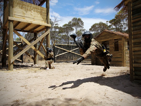 Player Leaps Mid-Air Holding Paintball Gun Vietcong Village