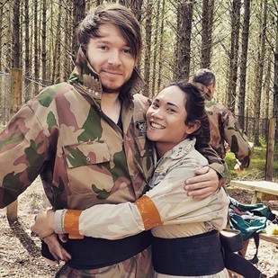 Couple embrace in paintball gear