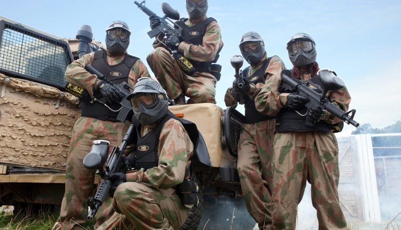 Paintball Players Pose Against Armoured Truck