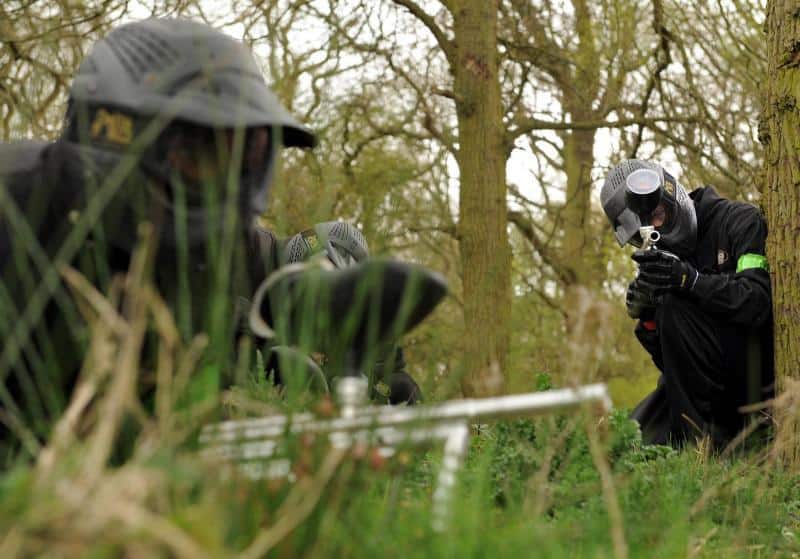 Crouching player takes aim behind tree