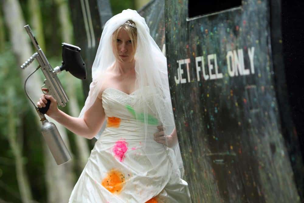 Paint-splattered bride poses with gun