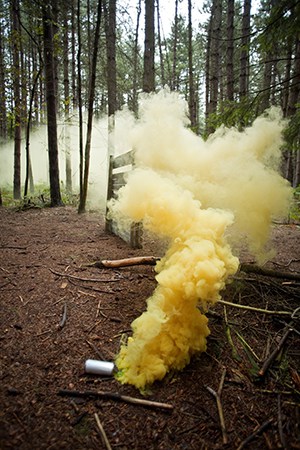 Bright coloured smoke rising from grenade on floor