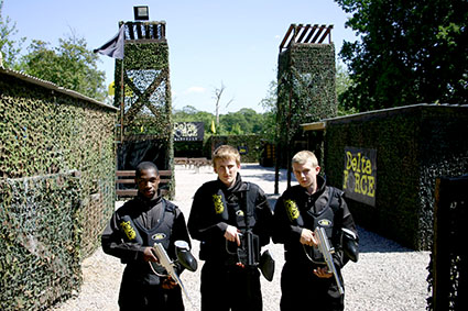 Three kids display different paintball guns