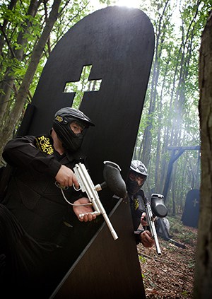 Two players hide on either side of gravestone