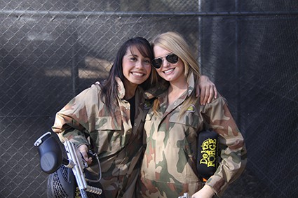 Two women smile with Delta Force guns