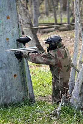 Kneeling player takes fire behind tree