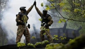 Two Paintball Players High Five with Each Other