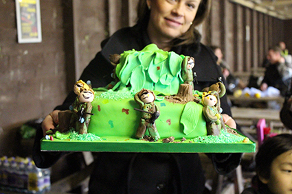 Woman holds up green paintball birthday cake