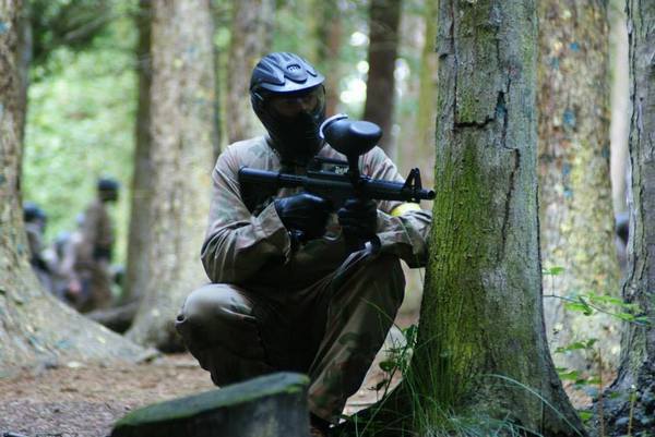 Player crouches behind tree with M16