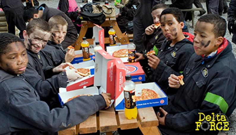 Kids eat pizza at base camp