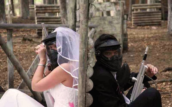 Couple pose for paintball wedding