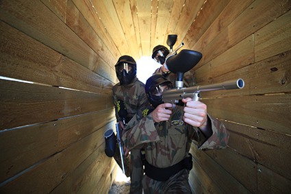 Three Players Advance Through Wooden Tunnel in Paintball Edinburgh